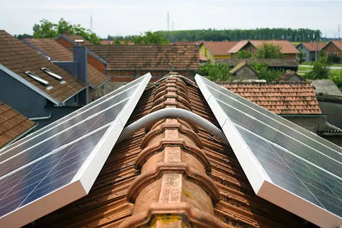 Solar panels mounted on both sides of a residential roof ridge
