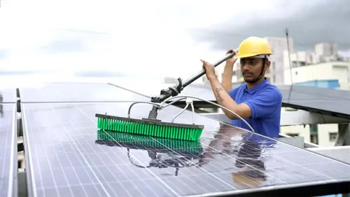 Technician cleaning solar panels on a rooftop